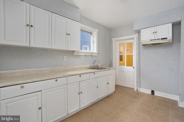 kitchen featuring white cabinetry, sink, and light tile patterned floors