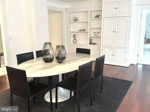 dining room featuring built in shelves and dark hardwood / wood-style floors