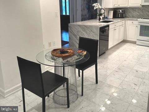 kitchen with white cabinetry, tasteful backsplash, black dishwasher, white range, and sink