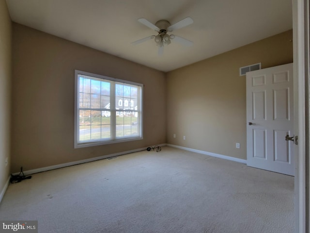 carpeted spare room featuring ceiling fan