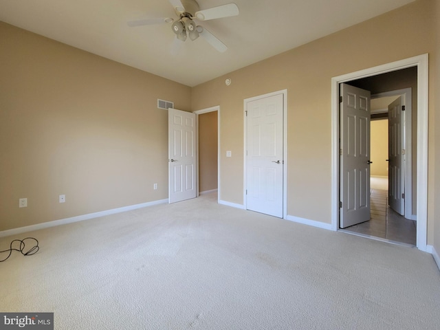 unfurnished bedroom featuring ceiling fan, a closet, and light carpet