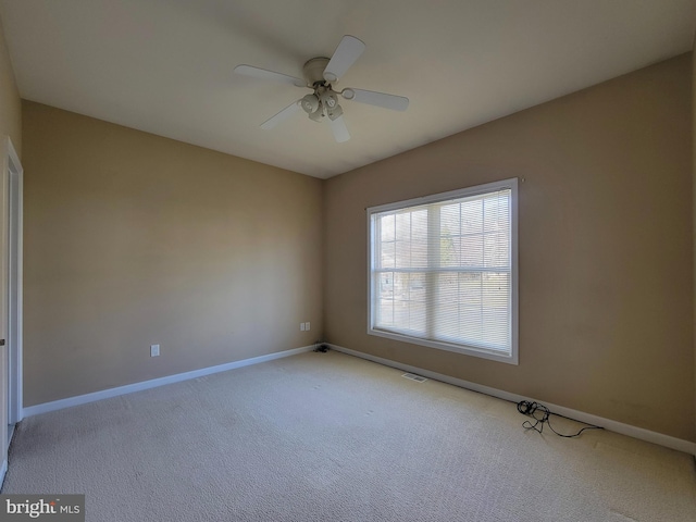 carpeted spare room with ceiling fan