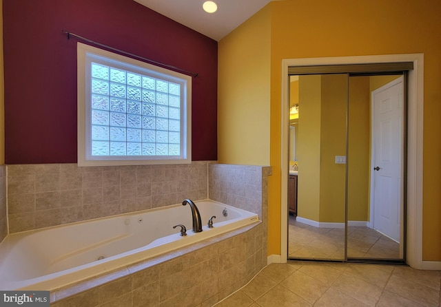 bathroom with tile patterned floors and tiled bath