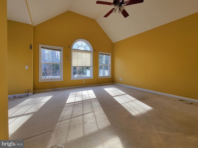 carpeted spare room with ceiling fan and high vaulted ceiling