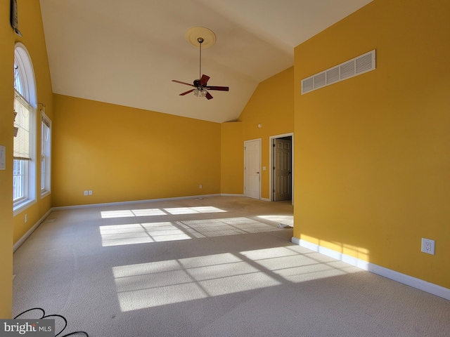 spare room with light carpet, high vaulted ceiling, and ceiling fan