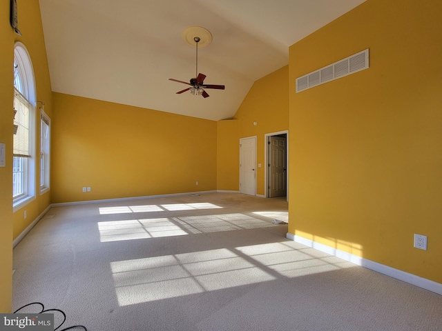 unfurnished room with ceiling fan, light carpet, and high vaulted ceiling