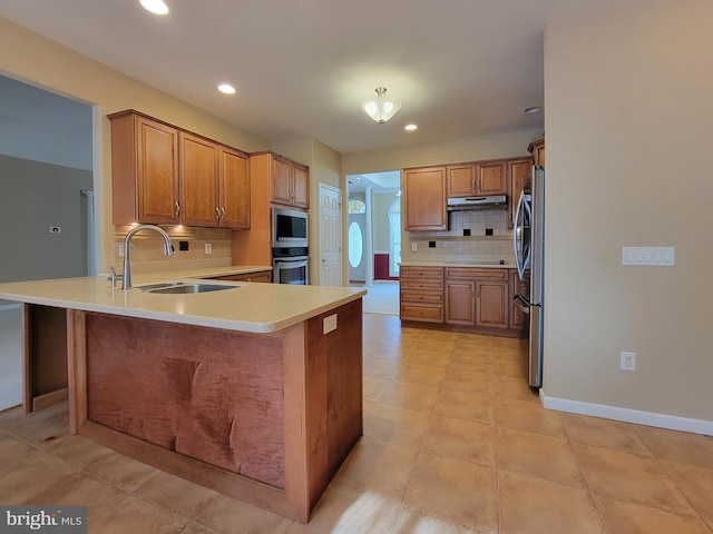 kitchen with sink, light tile patterned floors, tasteful backsplash, kitchen peninsula, and stainless steel appliances