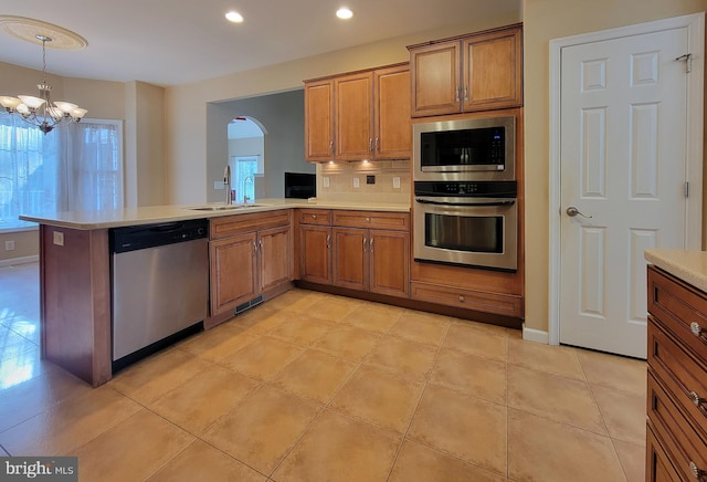 kitchen featuring kitchen peninsula, sink, stainless steel appliances, and a notable chandelier