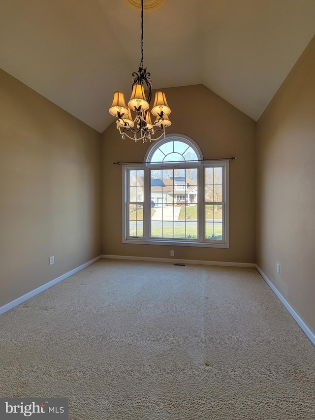 carpeted spare room with a chandelier and lofted ceiling