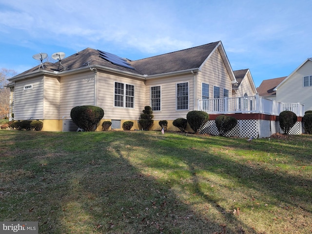 view of home's exterior featuring a lawn, solar panels, and a deck