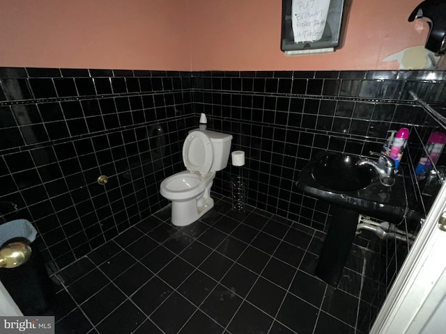 bathroom featuring sink, tile patterned flooring, tile walls, and toilet