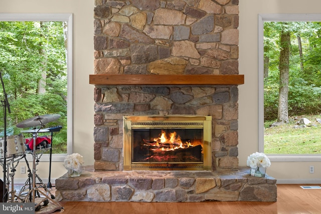 interior details featuring a stone fireplace and hardwood / wood-style floors