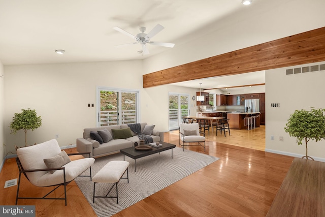 living room with lofted ceiling, light hardwood / wood-style floors, and ceiling fan