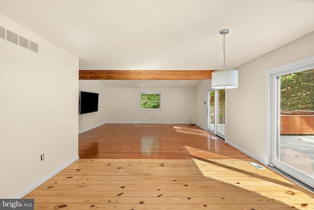 unfurnished living room with light wood-type flooring and beamed ceiling