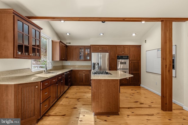 kitchen with lofted ceiling with beams, light hardwood / wood-style flooring, sink, appliances with stainless steel finishes, and a center island