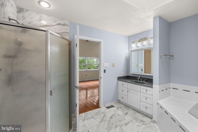 bathroom featuring walk in shower, vanity, and wood-type flooring