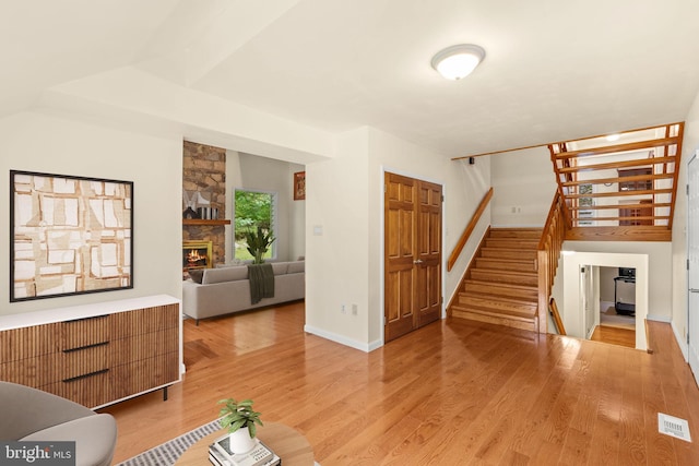 unfurnished living room with light hardwood / wood-style floors and a stone fireplace