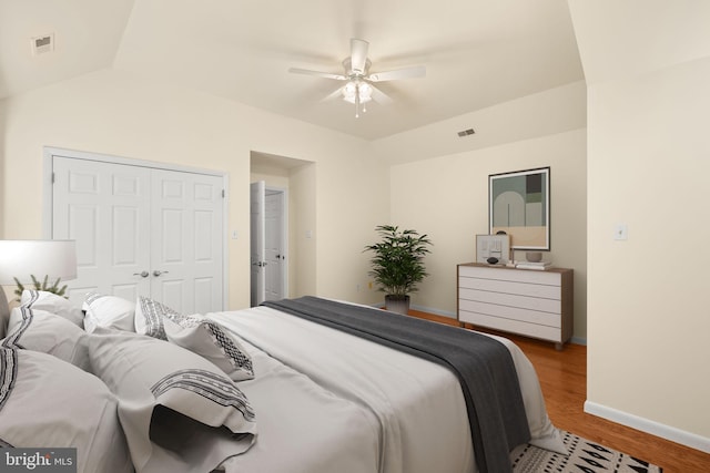 bedroom with a closet, vaulted ceiling, hardwood / wood-style flooring, and ceiling fan