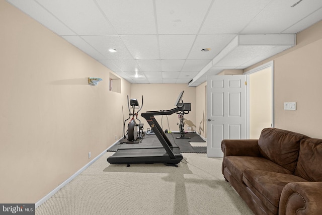 exercise room featuring a paneled ceiling and carpet floors