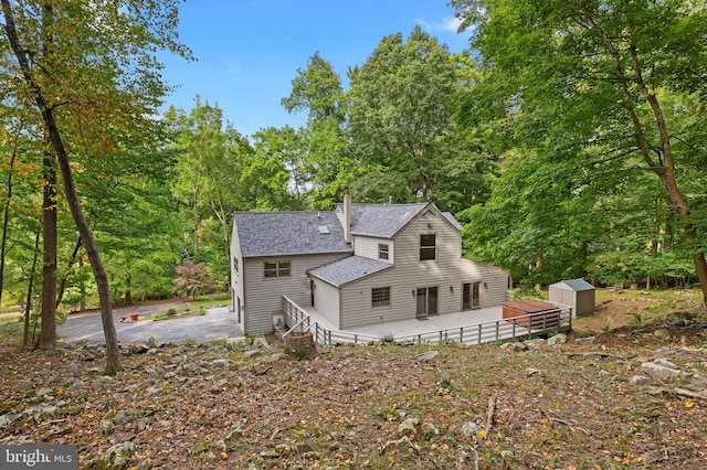 rear view of property featuring a storage shed