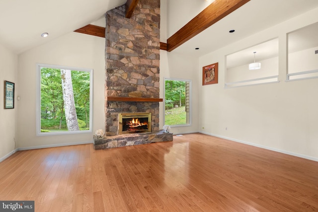 unfurnished living room featuring a fireplace, high vaulted ceiling, hardwood / wood-style floors, and beam ceiling