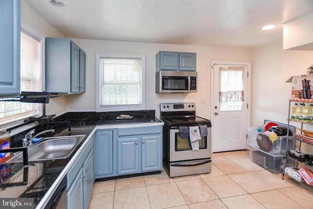 kitchen with blue cabinetry, stainless steel appliances, and a healthy amount of sunlight