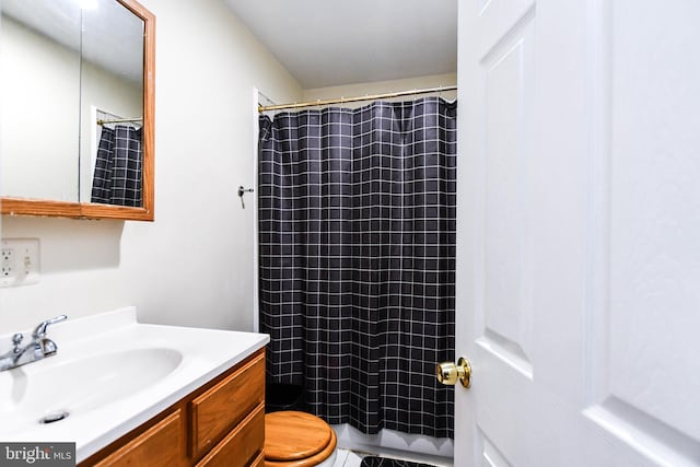 bathroom with curtained shower, vanity, and toilet