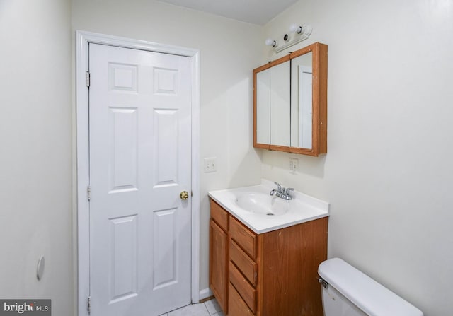 bathroom featuring tile patterned flooring, vanity, and toilet