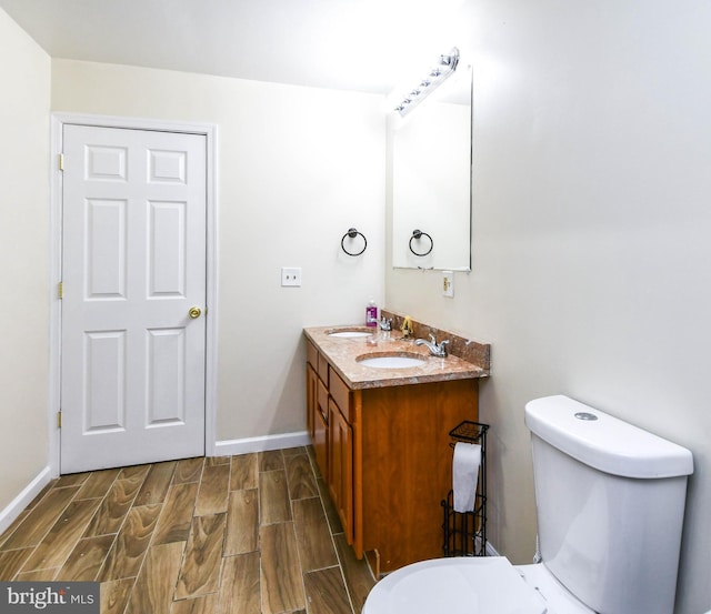 bathroom featuring vanity, toilet, and hardwood / wood-style flooring