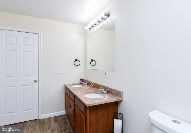 bathroom featuring hardwood / wood-style floors, vanity, and toilet