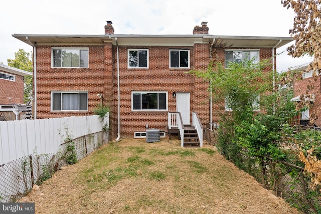 back of property with a yard and central AC unit