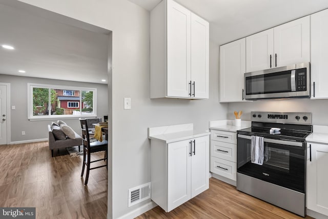 kitchen featuring light hardwood / wood-style floors, stainless steel appliances, and white cabinets