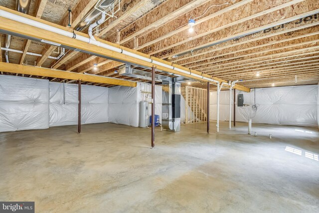 basement with heating unit, water heater, and electric panel