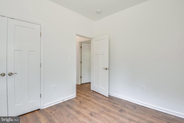 unfurnished bedroom featuring light hardwood / wood-style flooring and a closet