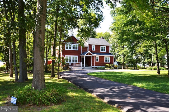 colonial inspired home with a front lawn