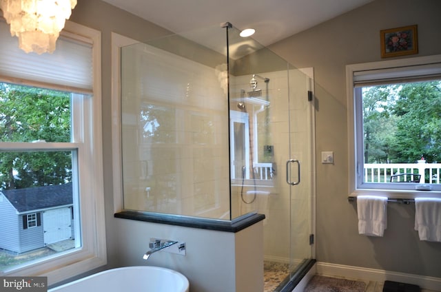 bathroom featuring walk in shower, an inviting chandelier, and plenty of natural light