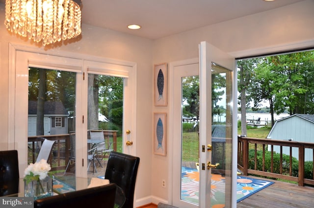 doorway to outside with an inviting chandelier and hardwood / wood-style floors