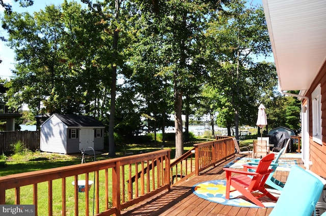 deck with grilling area, a yard, and a shed