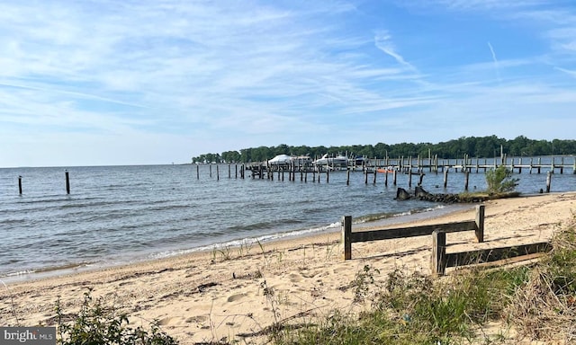 view of dock featuring a view of the beach and a water view