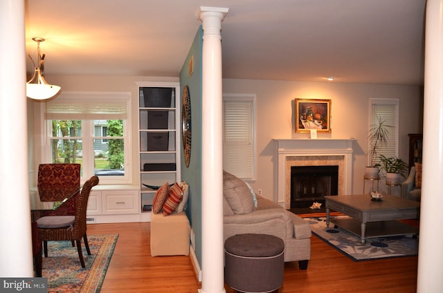 living room with hardwood / wood-style flooring and decorative columns