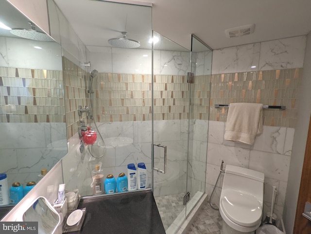 bathroom featuring tile walls, toilet, and an enclosed shower