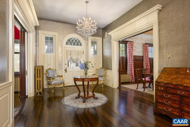 sitting room with an inviting chandelier, radiator, and dark wood-type flooring