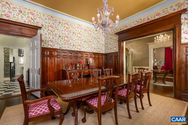 dining space with an inviting chandelier, crown molding, and hardwood / wood-style floors