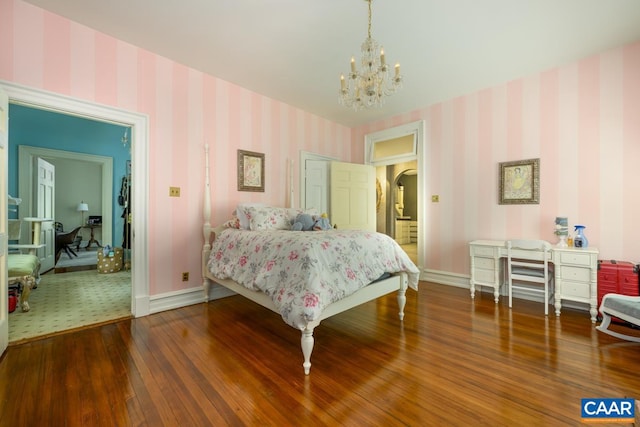 bedroom with an inviting chandelier and hardwood / wood-style floors