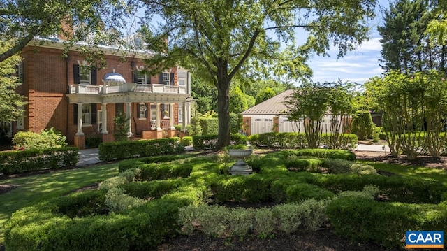 rear view of property with a lawn and a balcony