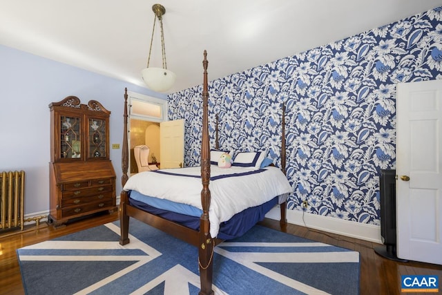 bedroom featuring radiator heating unit and dark wood-type flooring