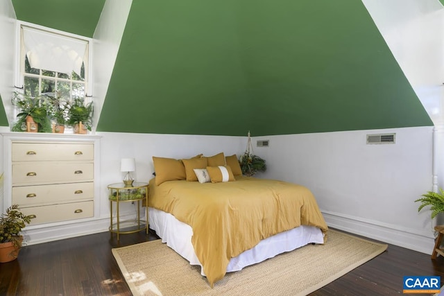 bedroom with vaulted ceiling and dark hardwood / wood-style flooring