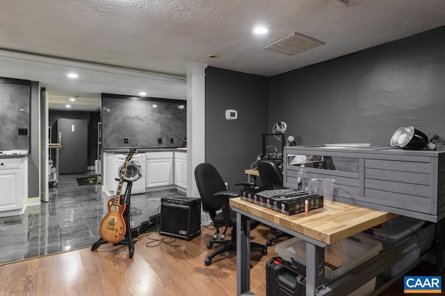 office area with hardwood / wood-style flooring, a textured ceiling, and washer / dryer