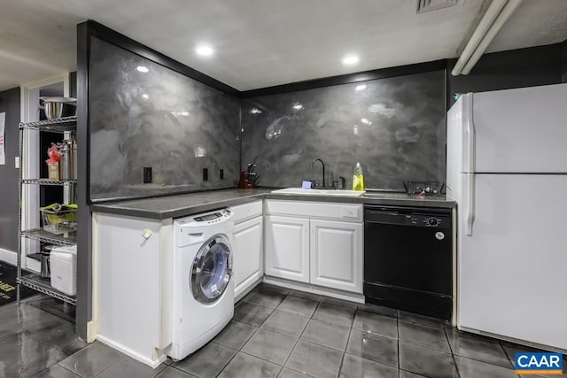 clothes washing area featuring sink, dark tile patterned floors, and washer / dryer