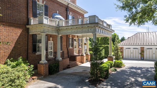 view of front of property featuring a balcony and a garage